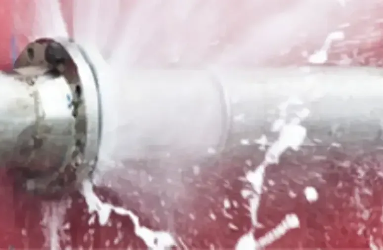 Water spraying from a failed joint on a metal supply pipe